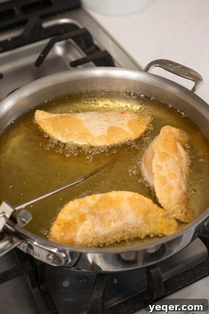 Quick Pizza Pockets 6 Pizza empanadas frying in hot oil until golden brown and crispy.