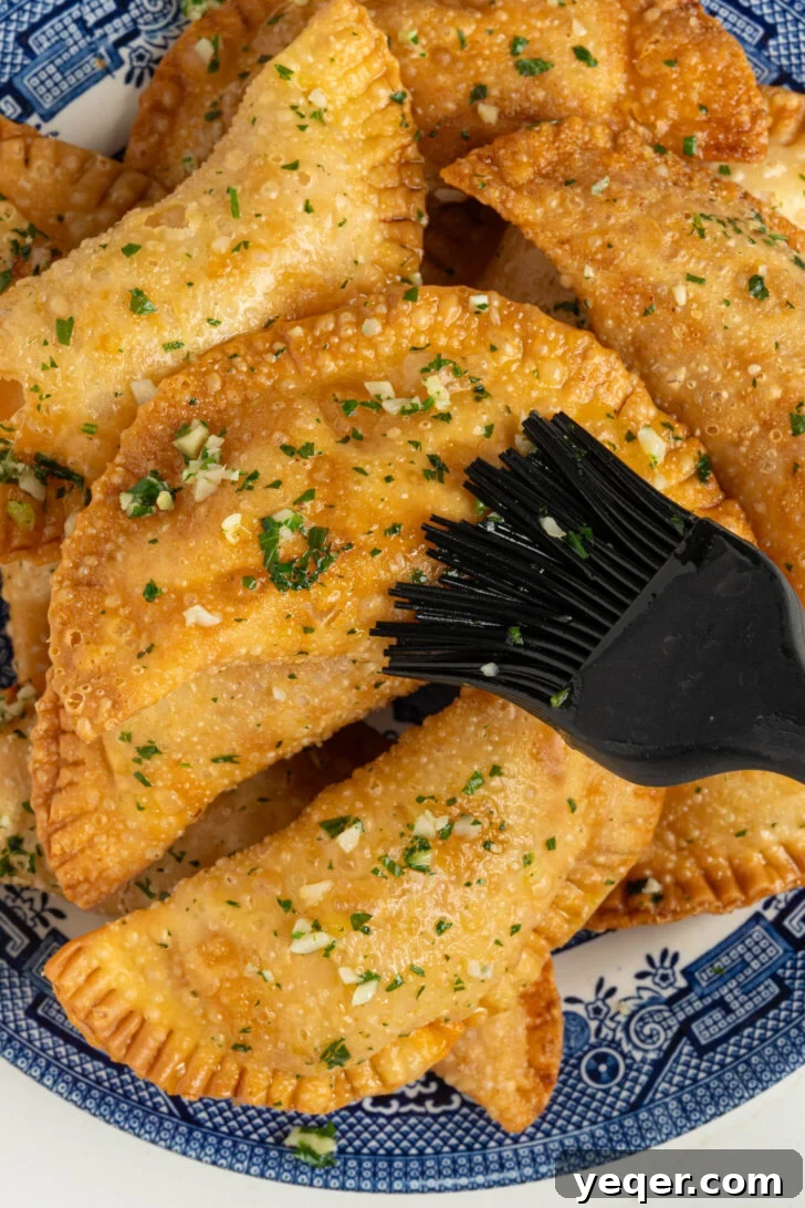 Quick Pizza Pockets 7 Brushing hot pizza empanadas with a freshly made garlic butter.