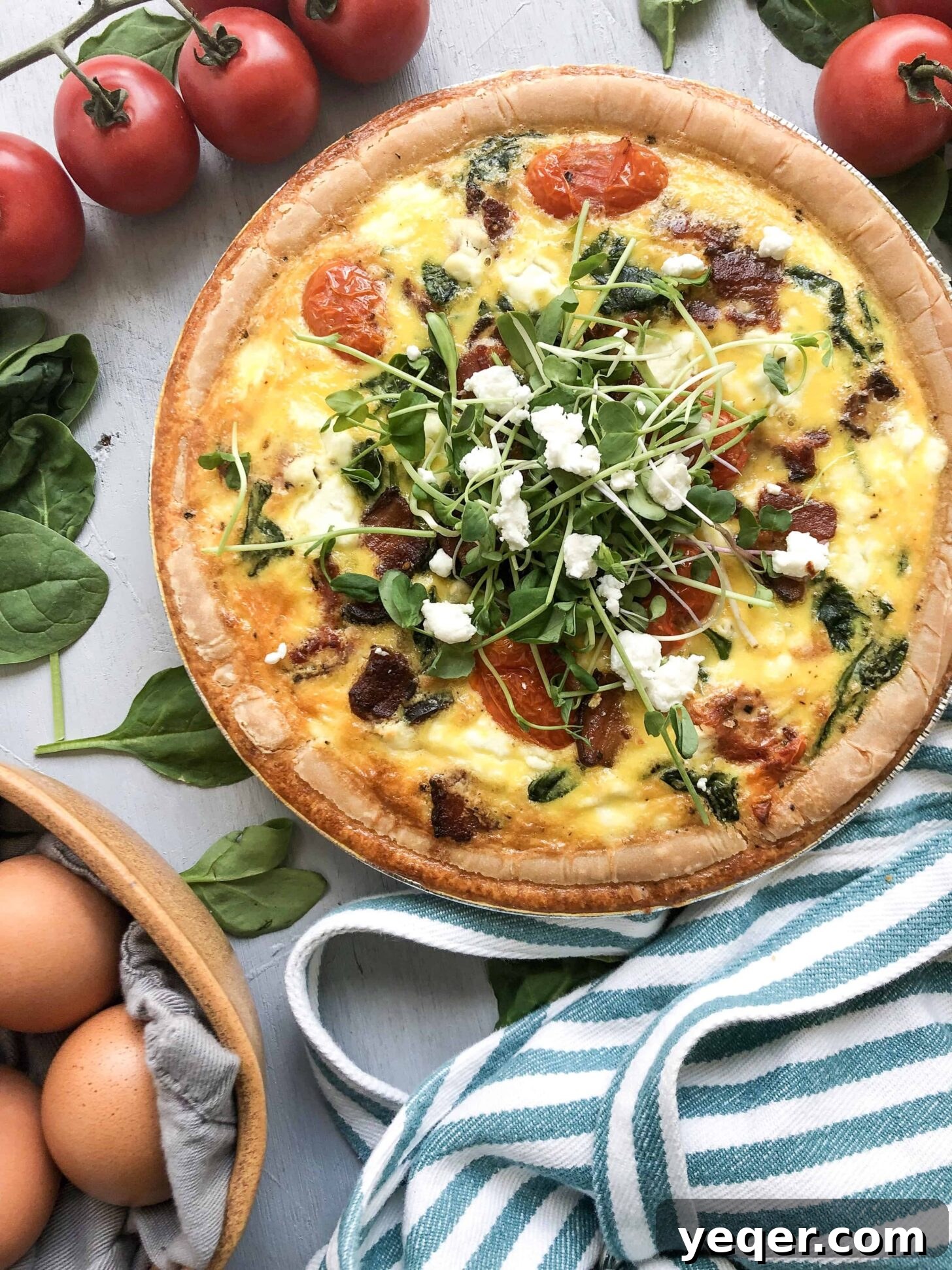 Mother's Day Brunch Dream Quiche 4 A close-up view of the baked Mother's Day Quiche, showcasing its golden crust and delicious filling of bacon, spinach, tomatoes, and goat cheese, ready to be sliced.