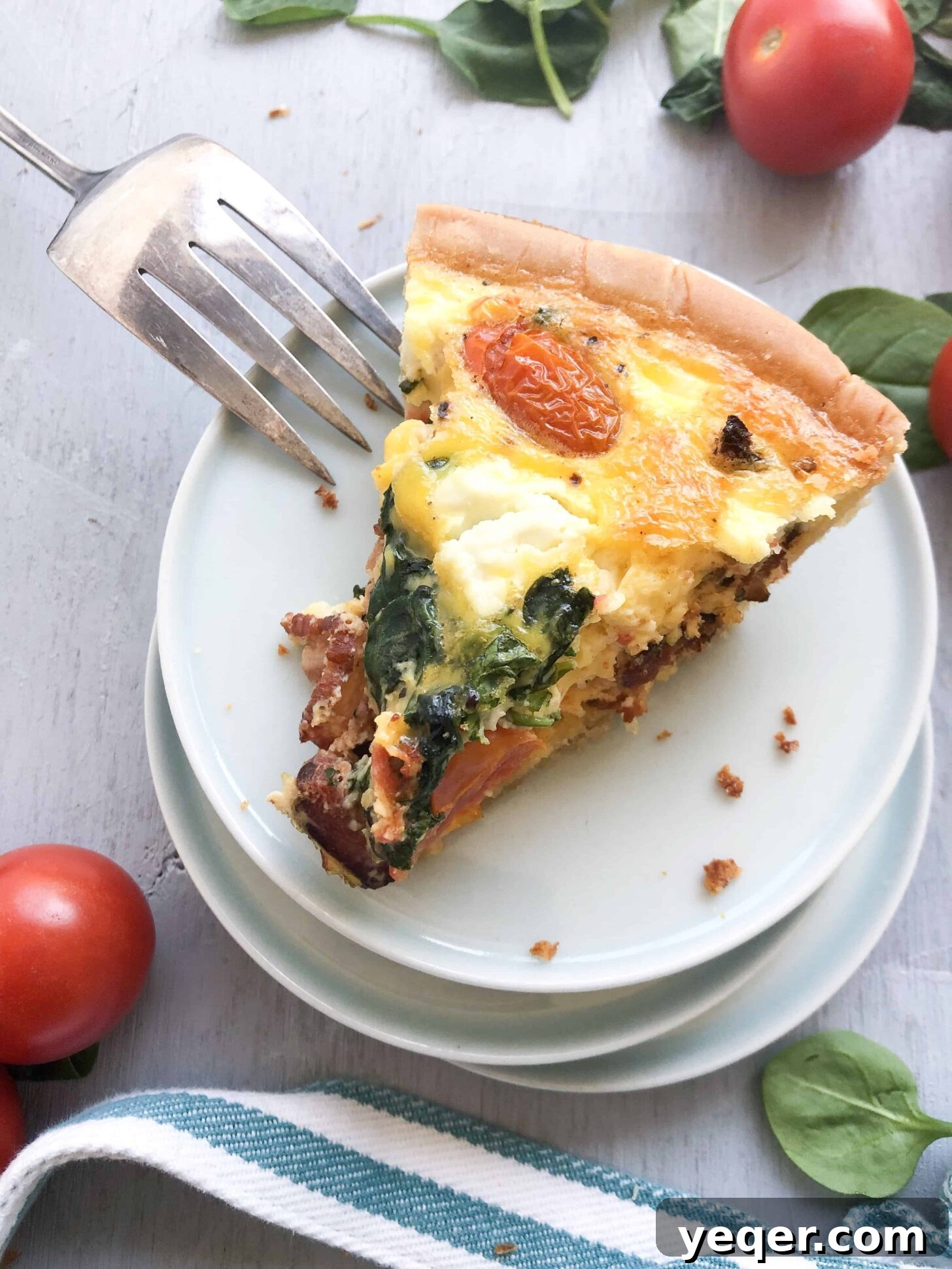 Mother's Day Brunch Dream Quiche 5 A single slice of the Mother's Day Quiche, perfectly cooked and presented on a charming blue plate, ready to be enjoyed as a gourmet brunch or breakfast.