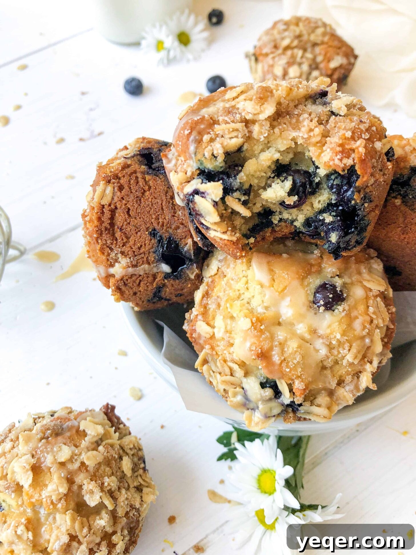 Irresistible Vegan Gluten-Free Blueberry Oat Muffins 5 A bowl of vegan blueberry muffins with a bite taken from one