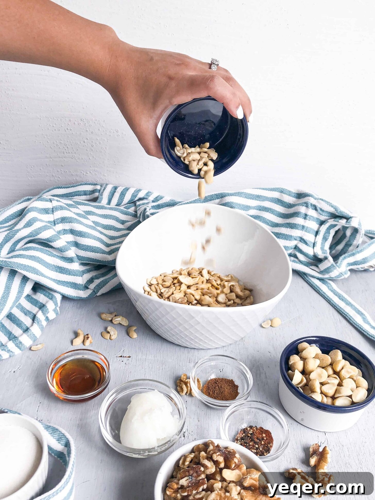 Artisan Spiced Nuts 4 A cascade of mixed nuts gently falling into a large mixing bowl, poised for their spiced coating.