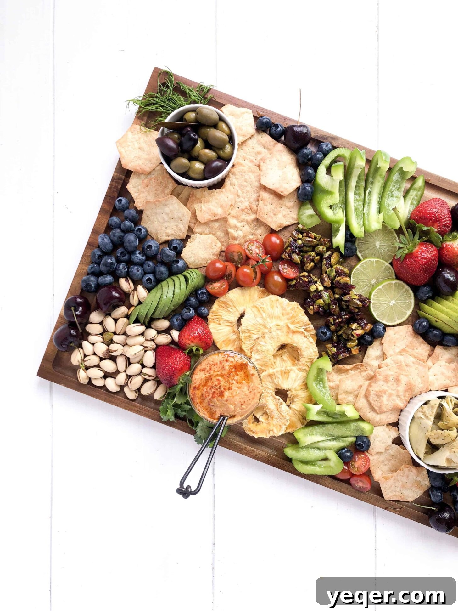 Botanical Bites Board 2 A beautifully arranged vegan charcuterie board, showcasing a variety of plant-based cheeses, fruits, vegetables, nuts, and crackers.