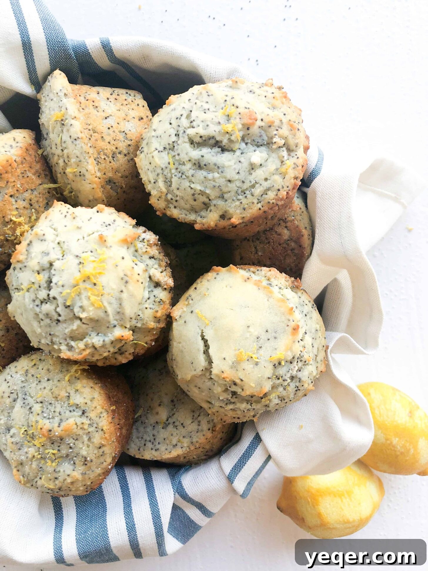 Moist Gluten-Free Poppy Seed Muffins 5 A charming basket filled with golden-brown gluten-free poppyseed muffins, dusted with glaze and poppy seeds.