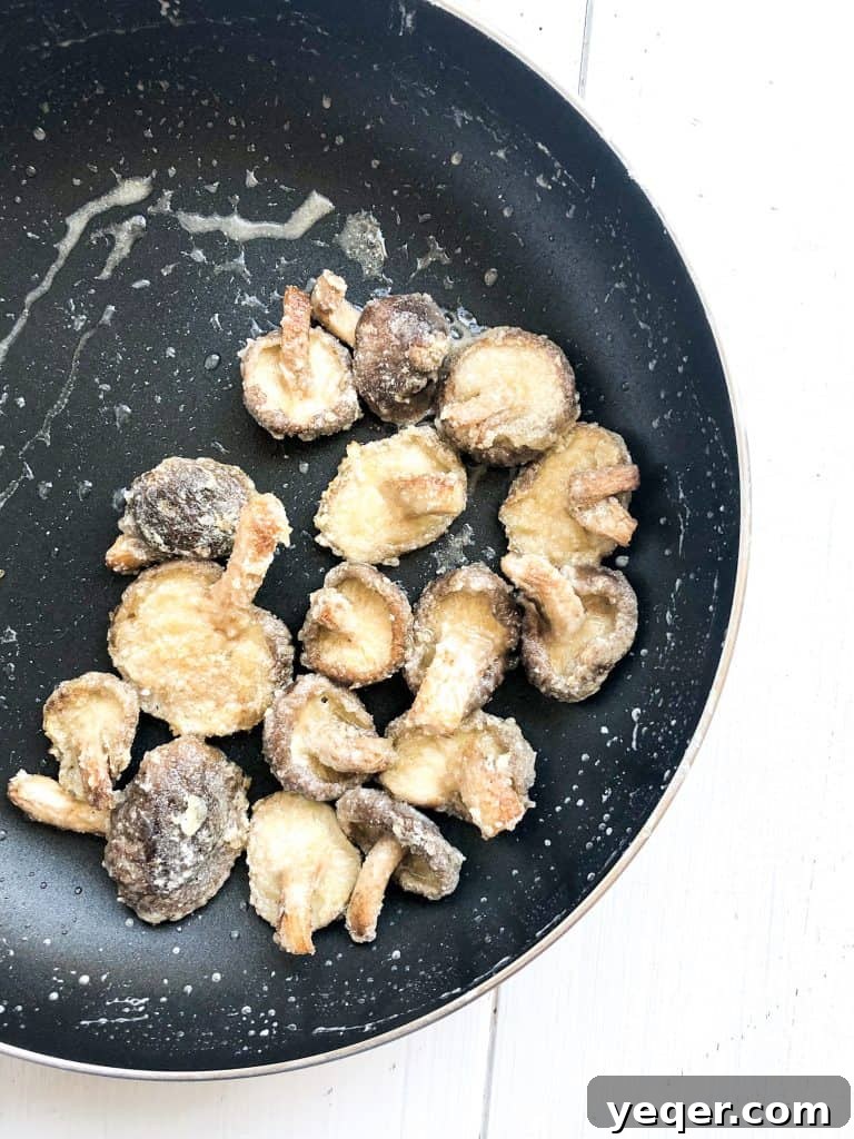 Crispy, pan-fried shiitake mushrooms coated in a rich, glossy sauce, ready to be served.
