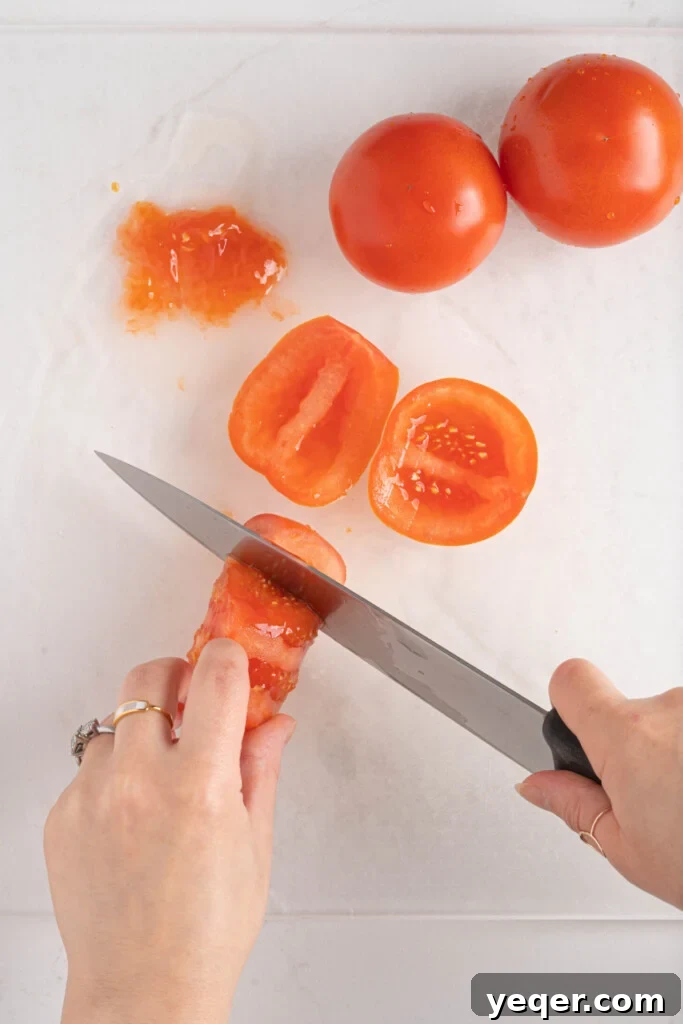 Vibrant Moroccan Tomato Salad 4 Hands dicing fresh, ripe tomatoes on a clean wooden cutting board, preparing them for a Moroccan tomato salad.