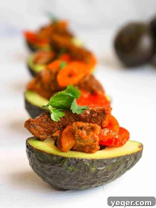 A lineup of Puerto Rican Steak Stuffed Avocados, garnished and served.