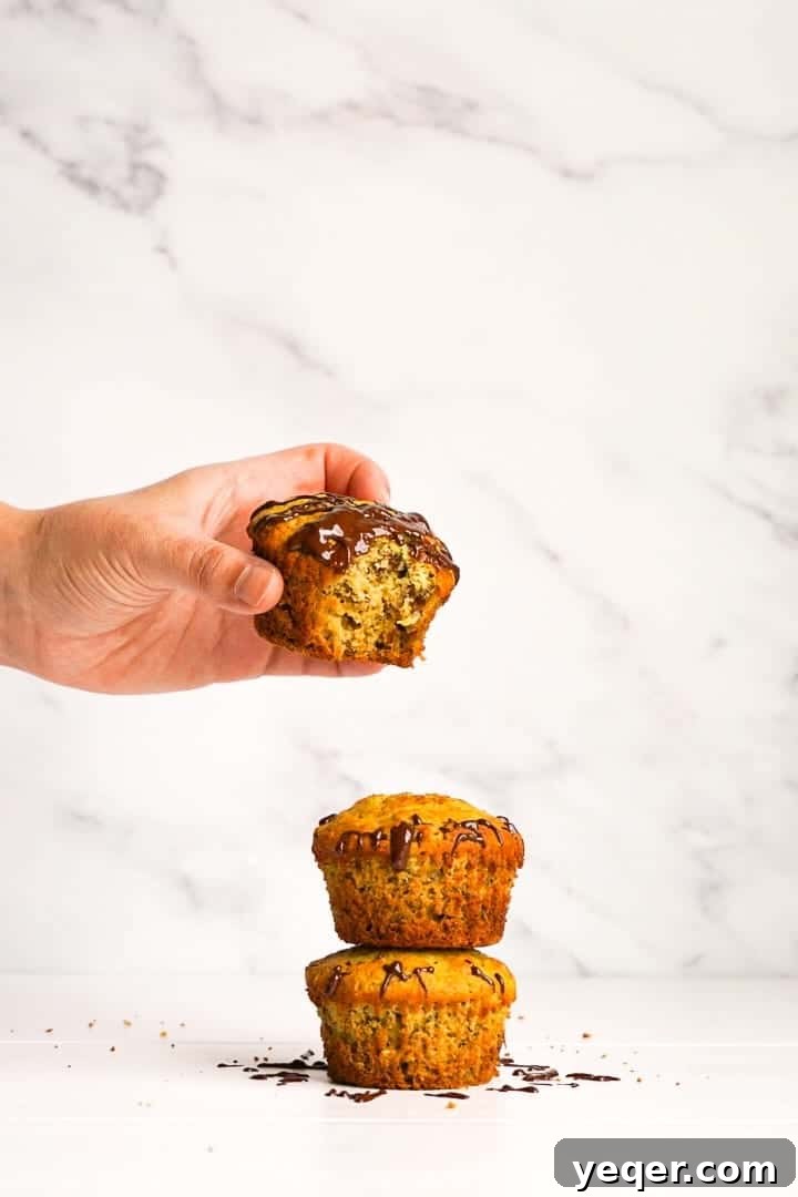 Decadent Chocolate-Swirled Banana Oat Muffins 2 Freshly baked gluten-free banana oat muffins with chocolate drizzle.
