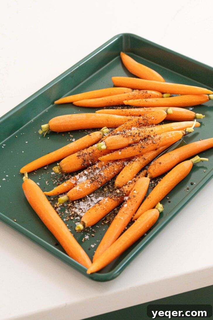 Harissa-Honey Roasted Carrots, Creamy Garlic Yogurt 3 Carrots with oil, salt and pepper on a sheet pan.