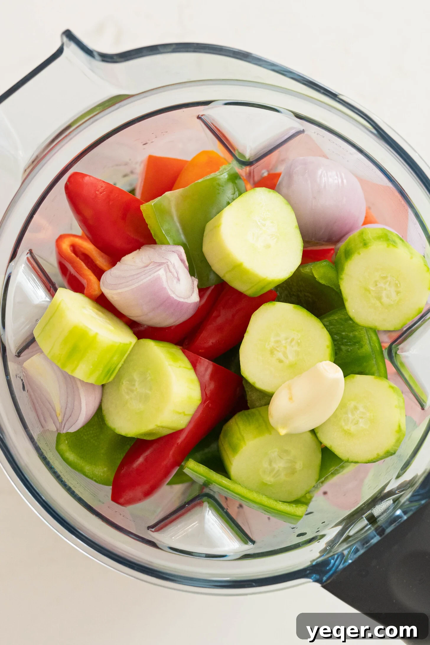 Classic Spanish Chilled Tomato Gazpacho 8 A high-powered blender filled with fresh, colorful vegetables like tomatoes, cucumbers, and peppers, ready to be blended into gazpacho.